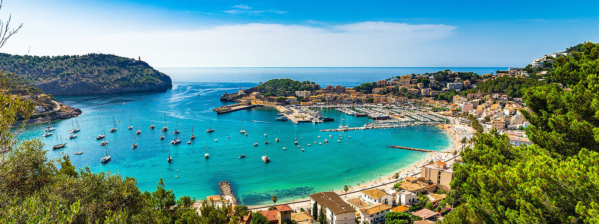 idyllisches Panorama einer mallorikinischen Bucht mit azurblauem Meer und Segelbooten